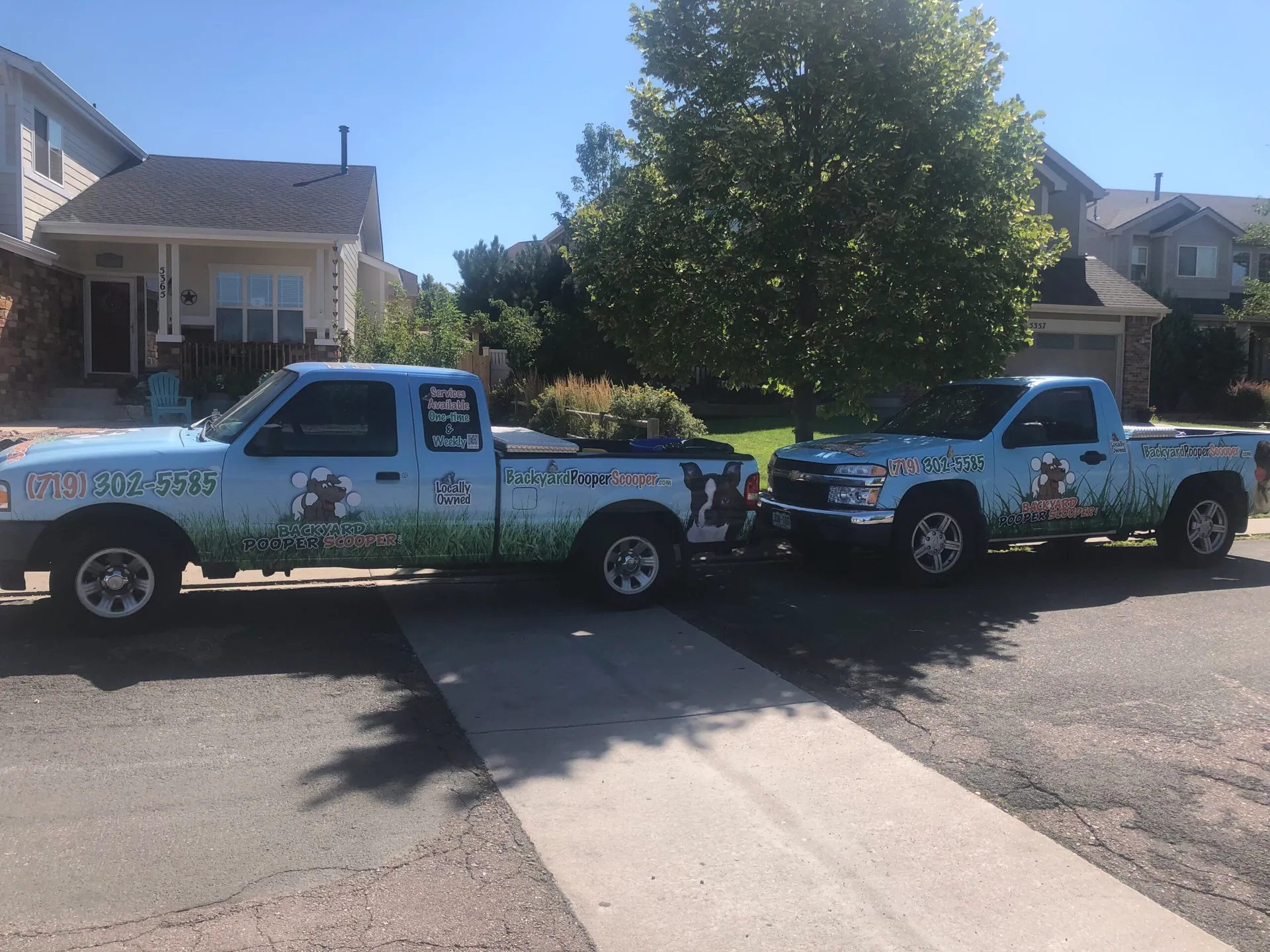 Backyard Pooper Scooper service trucks lined up in a neighborhood